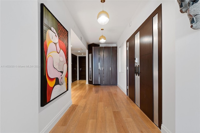 hallway with light hardwood / wood-style floors