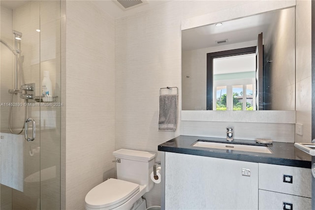 bathroom with walk in shower, vanity, and toilet