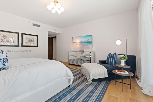 bedroom with a chandelier and wood-type flooring