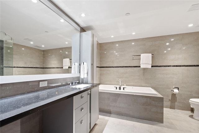 bathroom featuring tile walls, toilet, tile floors, and large vanity