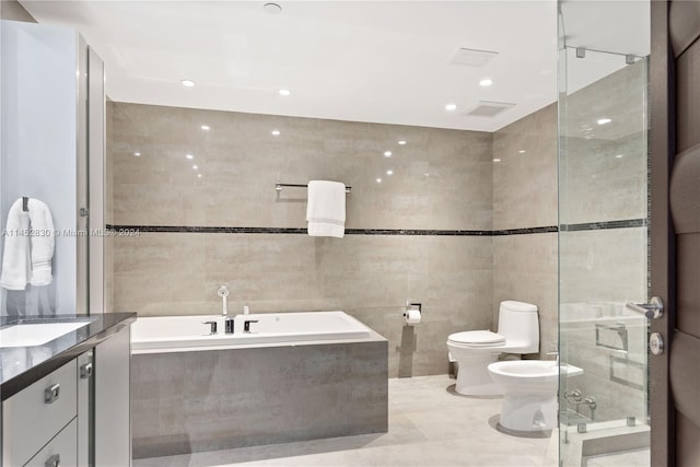 full bathroom featuring tile walls, a bidet, toilet, tile floors, and vanity