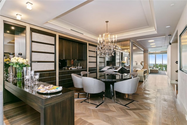 dining space with light parquet floors, a raised ceiling, and a chandelier