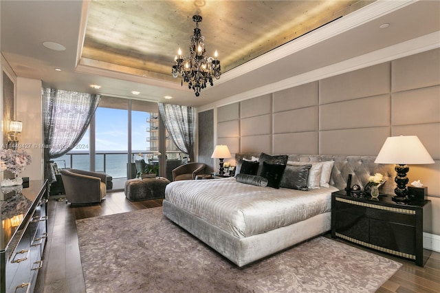 9705 Collins Ave Unit 1803N, Bal Harbour, FL 33154 - bedroom with dark wood-style flooring, a water view, a tray ceiling, a chandelier, and floor to ceiling windows