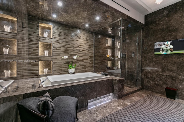 bathroom featuring independent shower and bath and tile walls