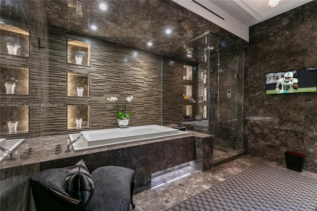 9705 Collins Ave Unit 1803N, Bal Harbour, FL 33154 - bathroom with tile walls, a garden tub, marble tiled flooring, and a stall shower