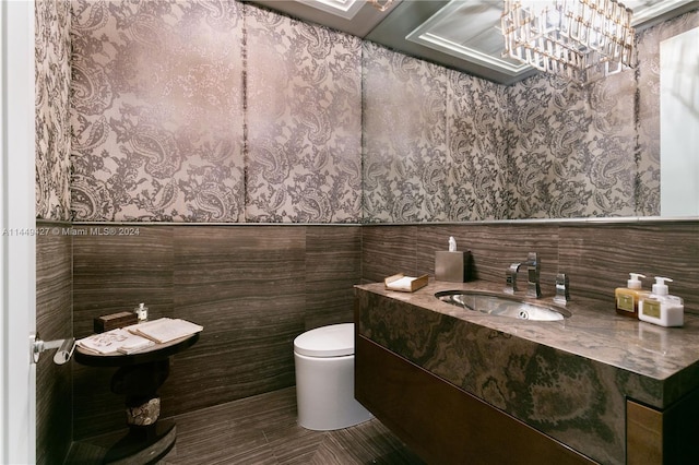 9705 Collins Ave Unit 1803N, Bal Harbour, FL 33154 - bathroom with toilet, a wainscoted wall, vanity, wallpapered walls, and tile walls