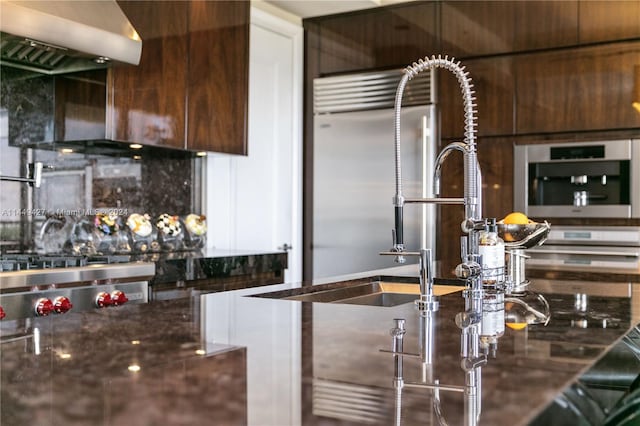 kitchen with built in refrigerator and tasteful backsplash