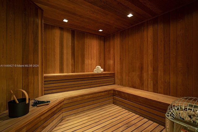 view of sauna / steam room featuring wood ceiling and wooden walls