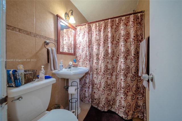 bathroom featuring toilet and tile walls