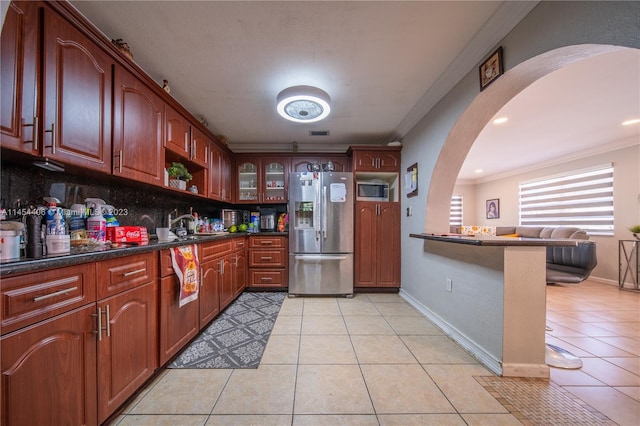 kitchen featuring light tile floors, crown molding, tasteful backsplash, and stainless steel appliances