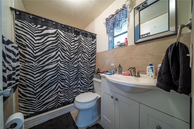 bathroom with backsplash, tile walls, large vanity, and toilet