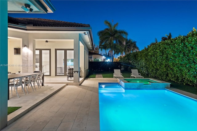 pool at twilight featuring a patio area, an in ground hot tub, and ceiling fan