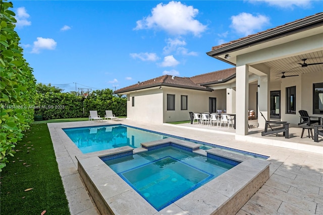 view of swimming pool featuring an in ground hot tub, ceiling fan, and a patio area