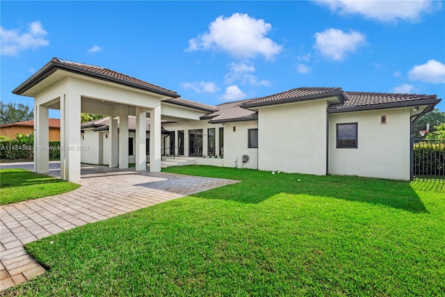 back of house with a lawn and a patio