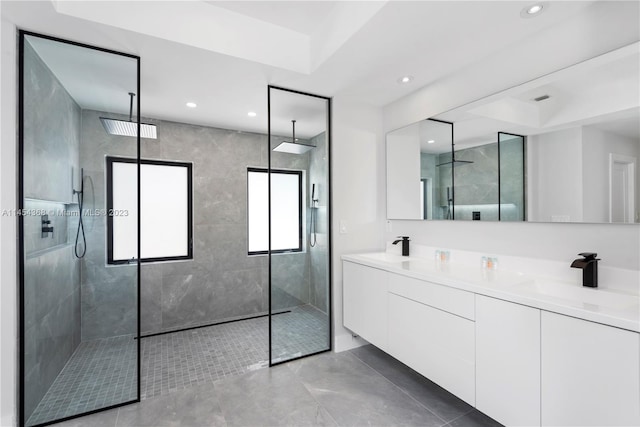 bathroom with double sink vanity, tile flooring, a tray ceiling, and walk in shower