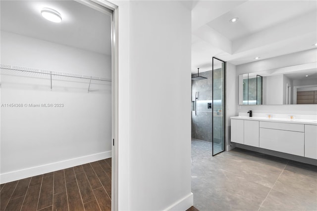 bathroom with wood-type flooring, a shower with door, and vanity