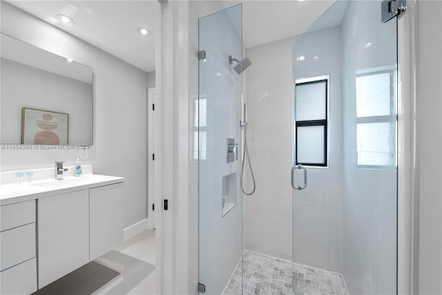 bathroom featuring tile floors, a shower with shower door, and vanity