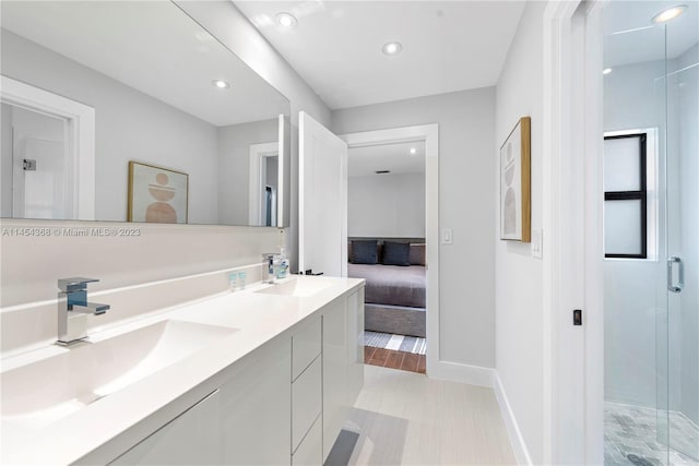 bathroom featuring walk in shower, double sink, vanity with extensive cabinet space, and tile flooring