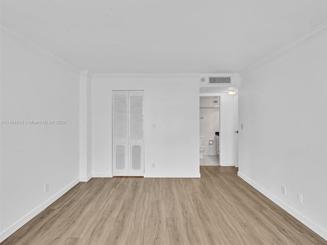 empty room with light wood-type flooring and ornamental molding