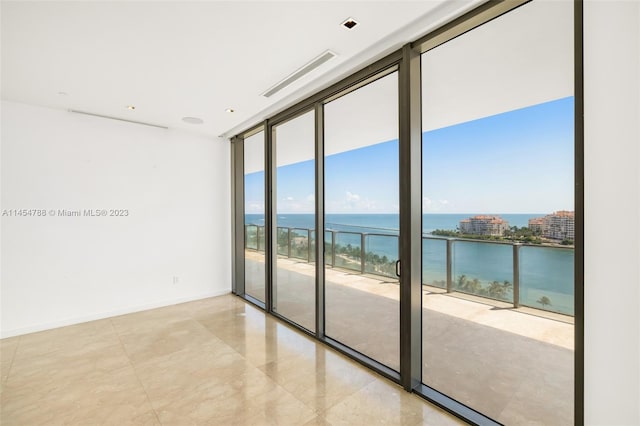 tiled empty room with expansive windows and a water view