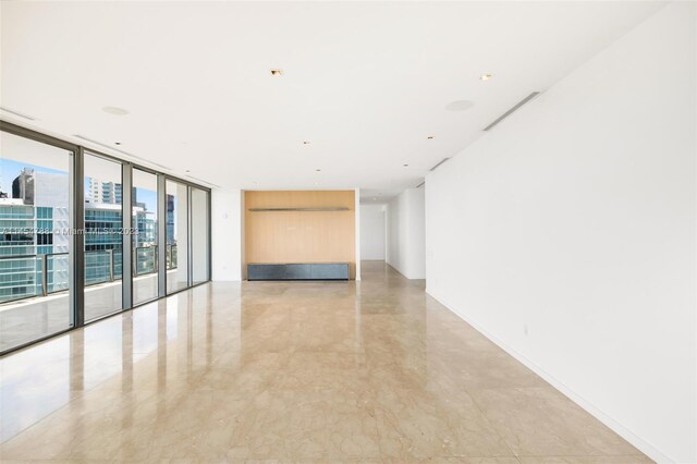 tiled spare room featuring floor to ceiling windows