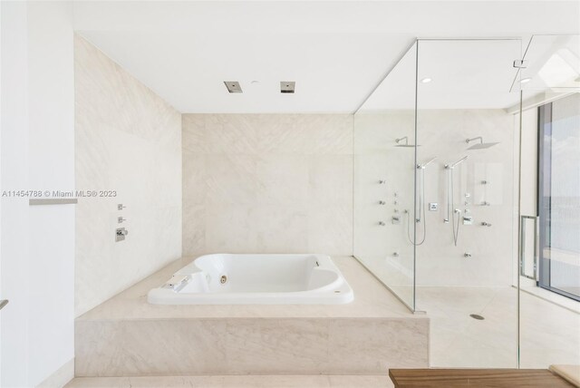 bathroom featuring tile flooring and separate shower and tub