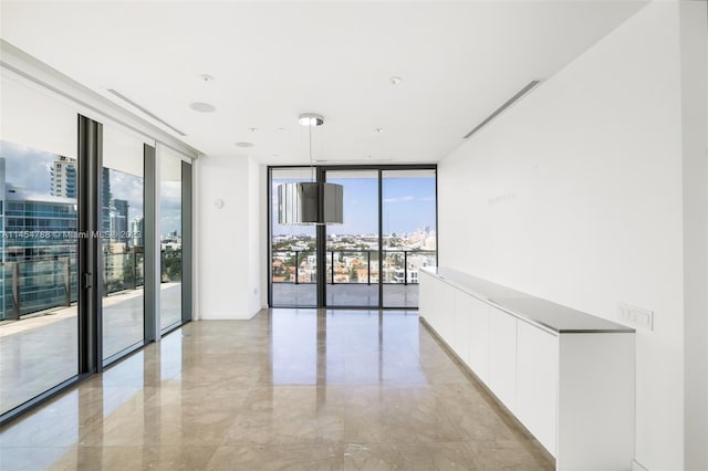 empty room with expansive windows and light tile floors