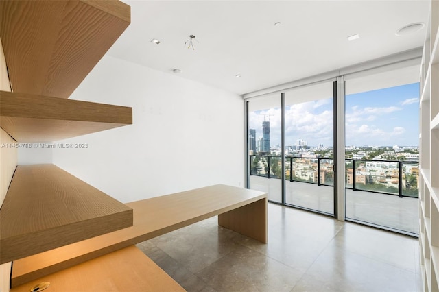 empty room featuring light tile flooring and a wall of windows