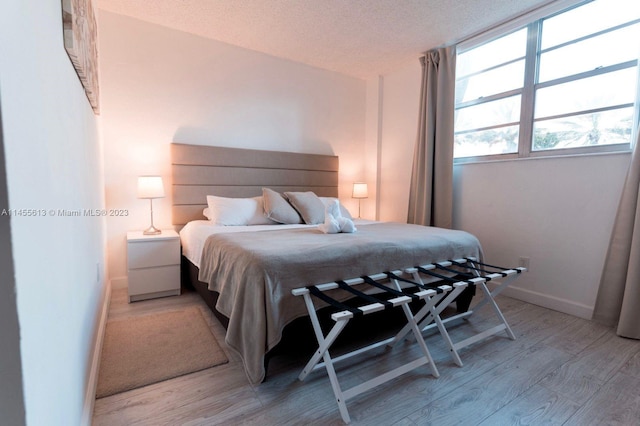 bedroom featuring a textured ceiling and light wood-type flooring