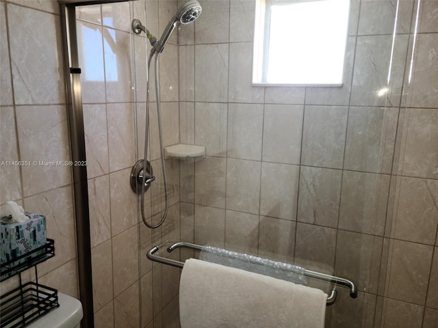 bathroom with toilet and a tile shower