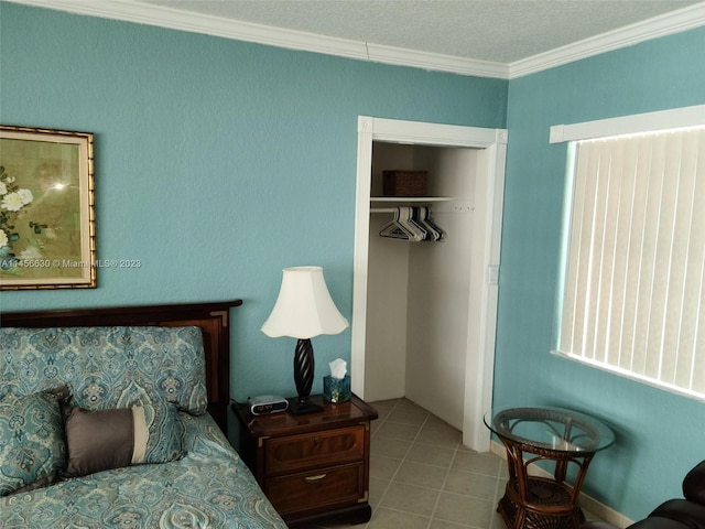 tiled bedroom featuring crown molding, a textured ceiling, and a closet