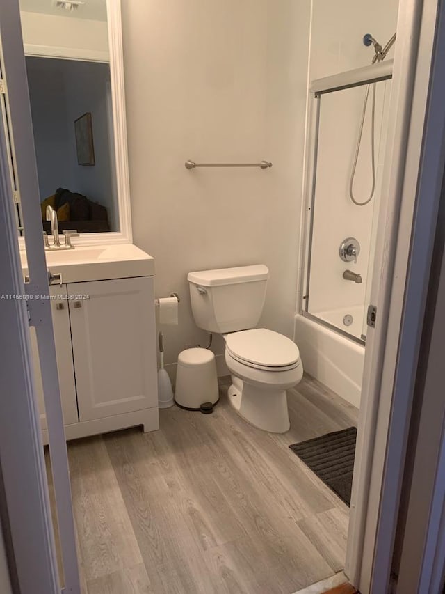 full bathroom featuring shower / bath combination with glass door, vanity, toilet, and wood-type flooring