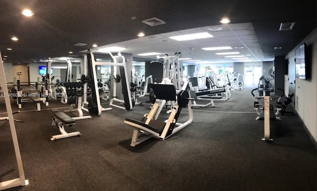 workout area featuring a paneled ceiling and carpet