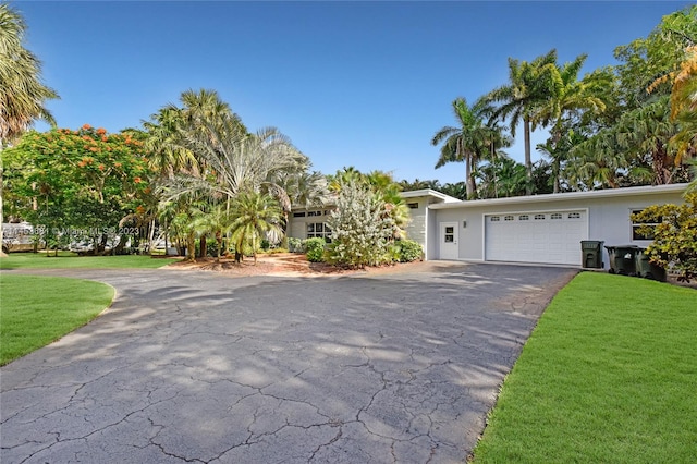 view of front of home with a front yard and a garage