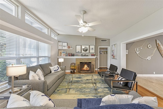 living room featuring a healthy amount of sunlight, hardwood / wood-style floors, ceiling fan, and a textured ceiling