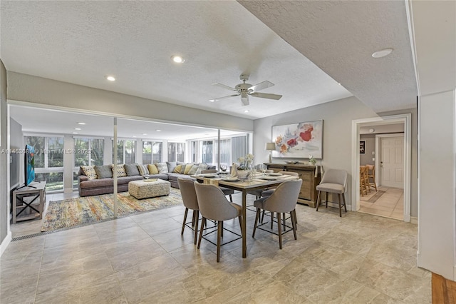 dining area with a textured ceiling, ceiling fan, and light tile floors