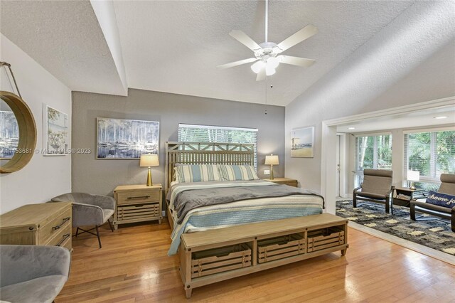 bedroom with lofted ceiling, multiple windows, ceiling fan, and light hardwood / wood-style flooring