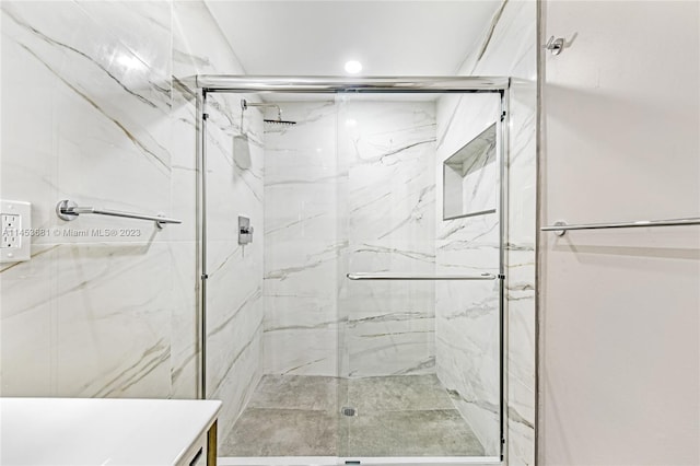 bathroom featuring tile walls, walk in shower, and vanity