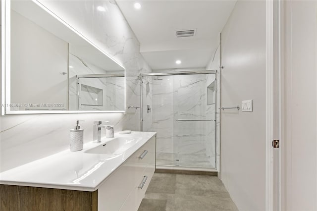 bathroom featuring a shower with door, tile floors, and oversized vanity