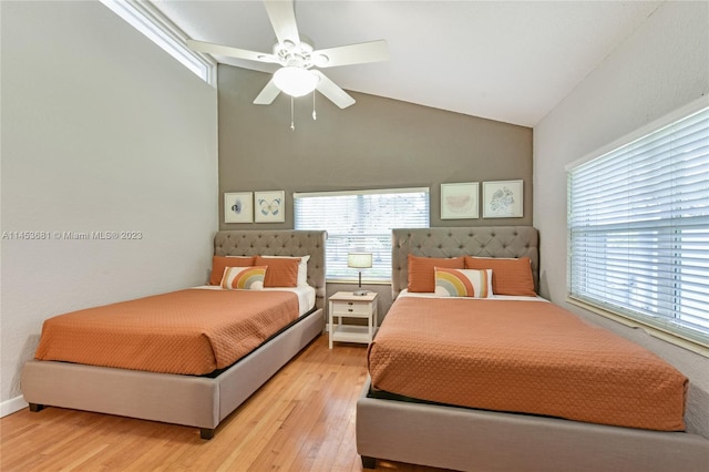 bedroom featuring multiple windows, ceiling fan, high vaulted ceiling, and light wood-type flooring