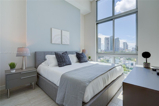 bedroom with floor to ceiling windows and light tile flooring