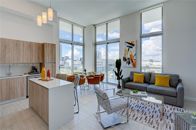 kitchen with a kitchen breakfast bar, hanging light fixtures, sink, and light tile floors