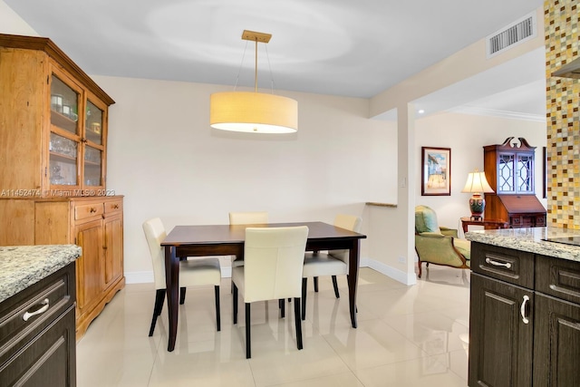 dining area with light tile flooring and ornamental molding