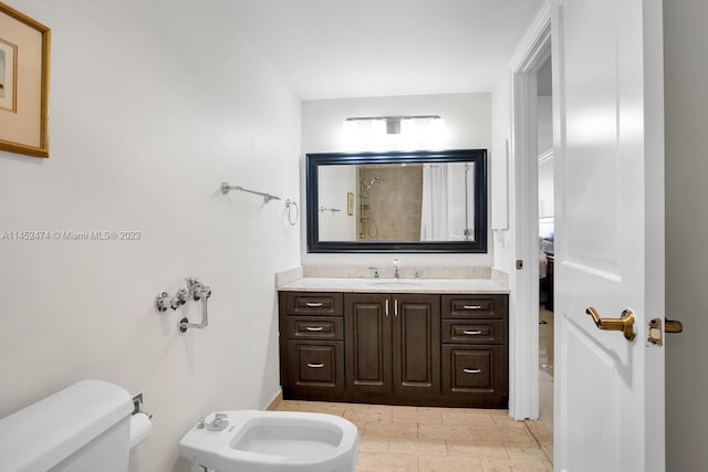 bathroom with a bidet, vanity, and toilet