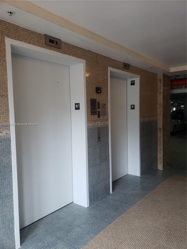 interior space with elevator and tile patterned flooring