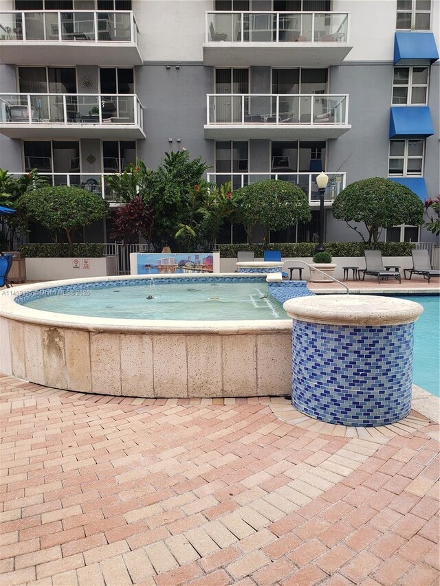 view of swimming pool featuring a jacuzzi