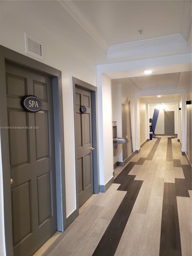 corridor with crown molding and wood-type flooring