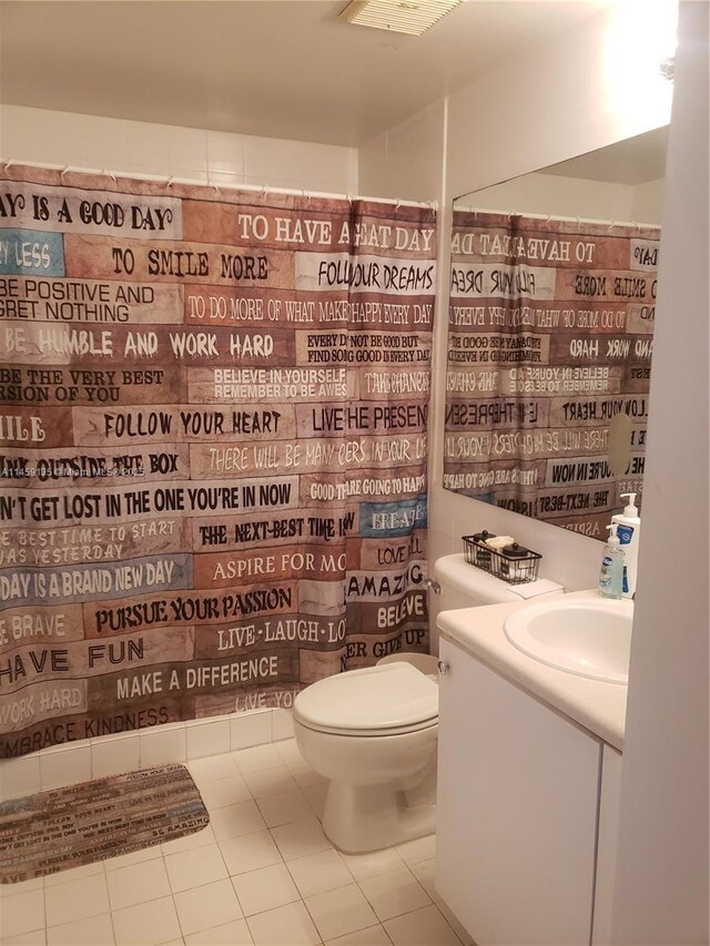 bathroom featuring tile patterned flooring, vanity, a shower with curtain, and toilet