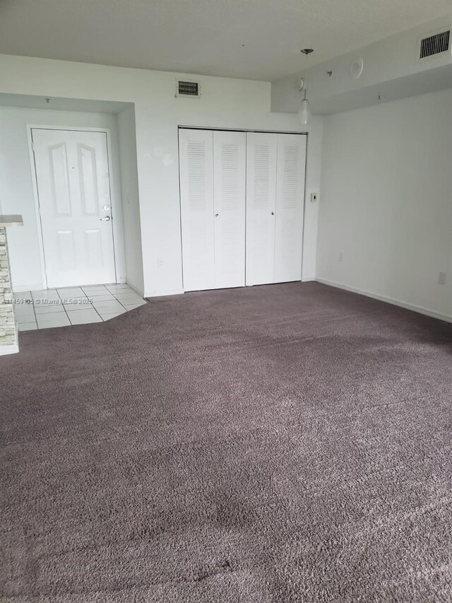 unfurnished living room with light carpet, electric panel, and a textured ceiling