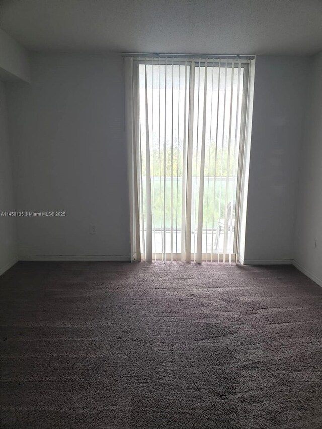 spare room with dark carpet